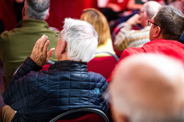 photo showing the backs of people sat in an audience.