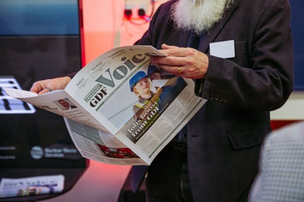 Man stood reading the GDF Voice newspaper